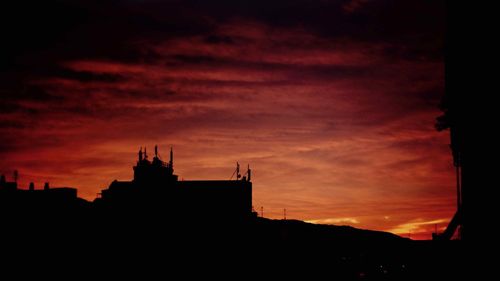 Silhouette of building against dramatic sky