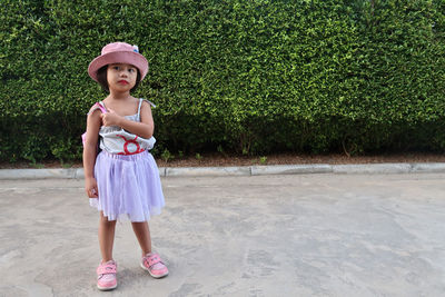 Full length portrait of cute girl standing outdoors