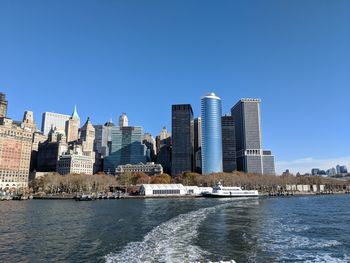 City at waterfront against blue sky