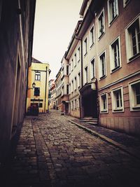 Empty alley amidst buildings in city