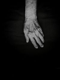 Close-up of human hand against black background