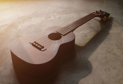 High angle view of guitar on table against wall