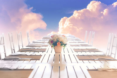 Low angle view of people on chair against sky