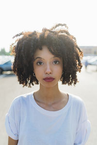 Young woman with curly hair on sunny day