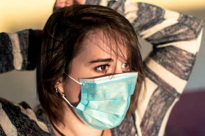 Close-up of beautiful woman wearing flu mask outdoors