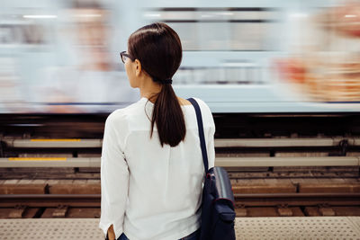 Full length of woman standing at railroad station