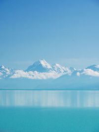 Scenic view of snowcapped mountains against blue sky