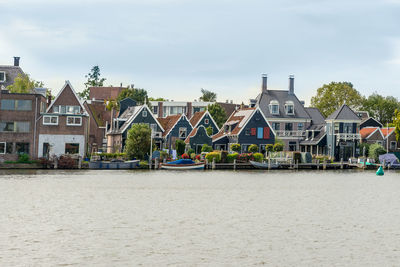 Houses by sea against sky