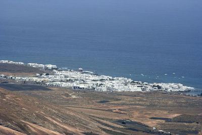 High angle view of city by sea against sky