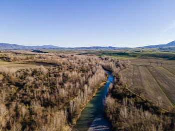 Panoramic view of road leading towards mountains against clear blue sky