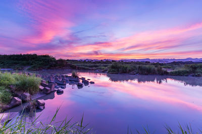 Scenic view of lake against sky at sunset