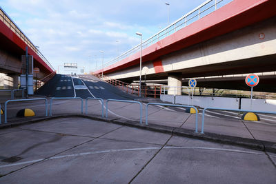 Road by bridge in city against sky