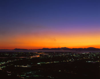 High angle shot of illuminated cityscape against sky during sunset