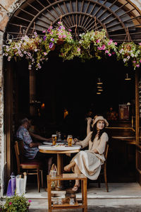 Woman looking away while sitting on chair at restaurant