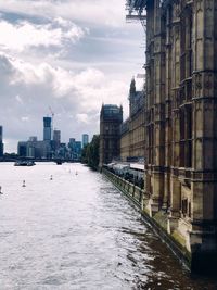 River amidst buildings in city against sky