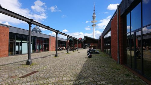 Rear view of woman on bicycle in city against sky