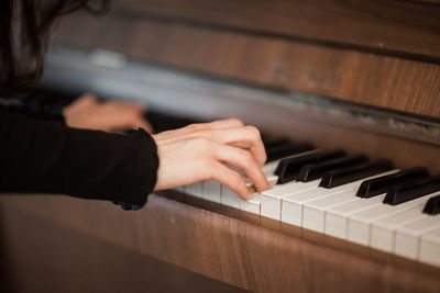 Cropped hands playing piano