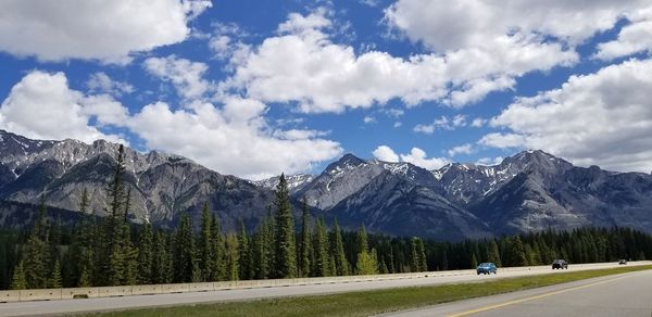 Road by mountains against sky