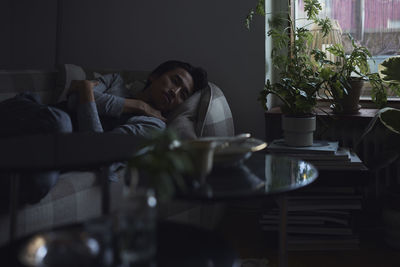 Sad man facing depression lying in bed