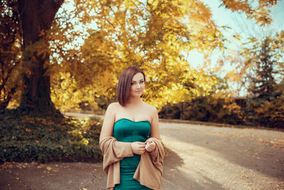 Portrait of young woman in park during autumn