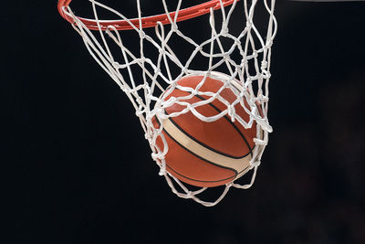 Low angle view of basketball hoop against black background