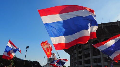 Low angle view of flags against sky