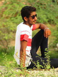 Full length of young man sitting on field