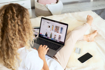 High angle view of woman shopping online at home