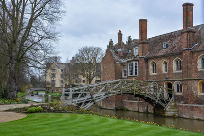 Bridge over canal by old building against sky