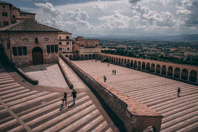 High angle view of people on buildings in city against sky