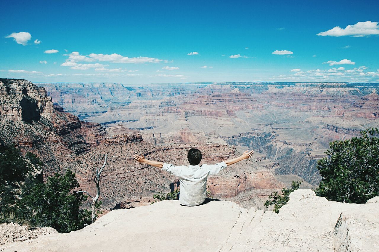 rock - object, rock formation, nature, scenics, rear view, real people, day, beauty in nature, one person, leisure activity, tranquil scene, outdoors, tranquility, physical geography, landscape, lifestyles, men, arid climate, women, mountain, sky, tree, young adult, adult, people