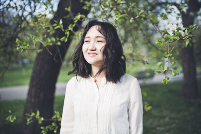 Optimistic young woman in a white blouse in a park. springtime