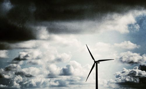 Low angle view of windmill against cloudy sky