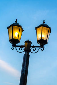 Low angle view of street light against blue sky