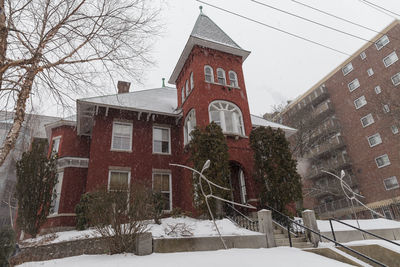 Low angle view of building and trees during winter