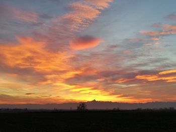 Scenic view of dramatic sky over land during sunset