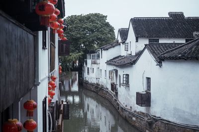 Canal amidst buildings in city against sky