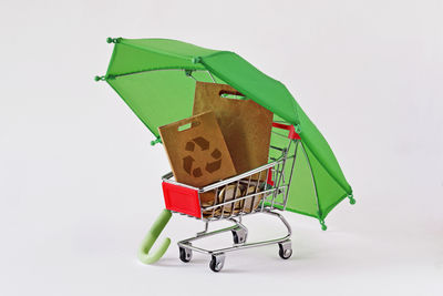 Close-up of shopping cart against white background