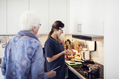 Nurse helping elderly woman at home