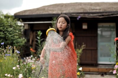 Girl watering plants in garden