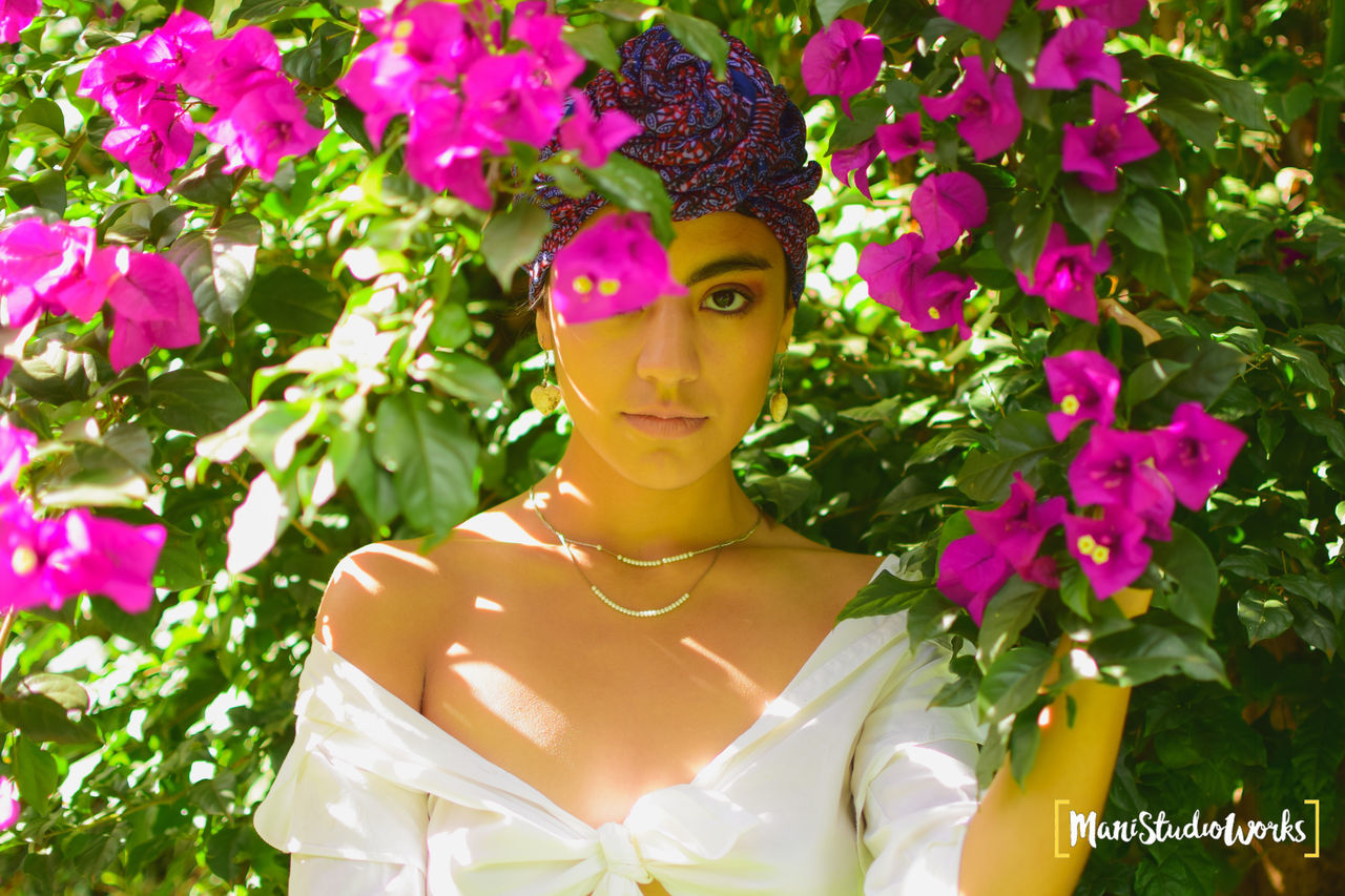 plant, one person, flowering plant, flower, front view, portrait, young adult, looking at camera, young women, nature, leisure activity, lifestyles, real people, women, beauty in nature, beautiful woman, green color, growth, beauty, pink color, outdoors, flower head, purple