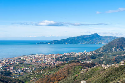 Aerial view of townscape by sea against sky