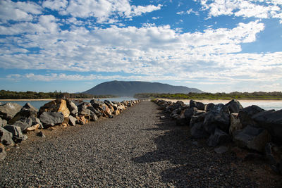 Stack of rocks on field against sky