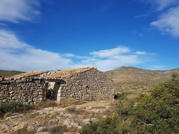 Old ruins on landscape against sky