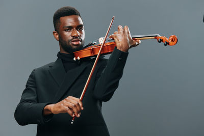 Midsection of man playing violin against white background