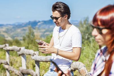 Side view of young man using mobile phone