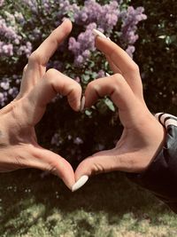 Close-up of hands making heart shape outdoors