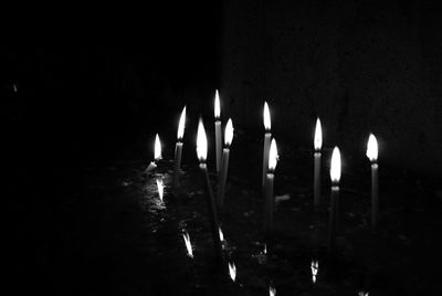 Close-up of lit candles against black background