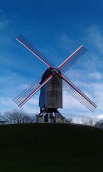 Traditional windmill on field against sky