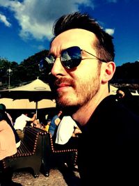 Close-up of man wearing sunglasses against sky